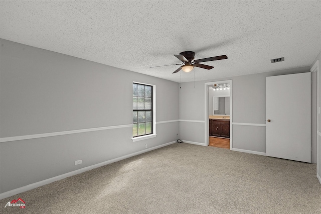 5630 Shreveport Blanchard Hwy, Shreveport, LA 71107 - unfurnished bedroom with carpet floors, a textured ceiling, baseboards, connected bathroom, and ceiling fan