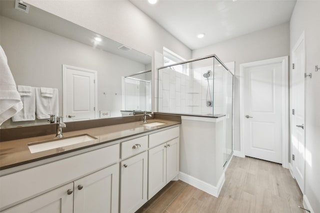 236 Mossy Cliff Ln, Fort Worth, TX 76052 - bathroom featuring a shower stall, double vanity, recessed lighting, wood finished floors, and baseboards