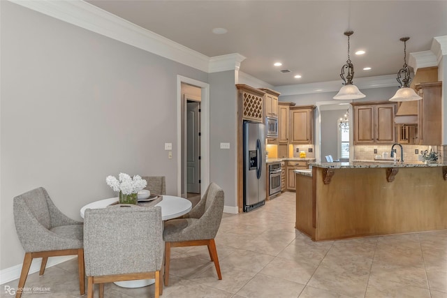 2549 Bloomfield Ln, Haughton, LA 71037 - kitchen featuring stainless steel appliances, backsplash, brown cabinetry, decorative light fixtures, and crown molding