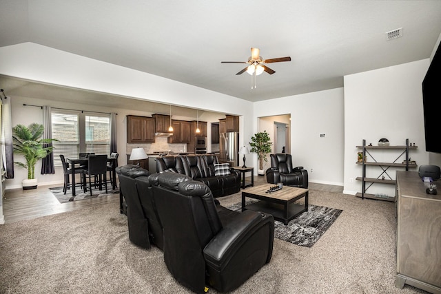 carpeted living room with a ceiling fan and baseboards