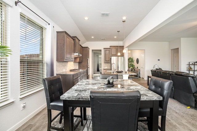 dining room with light wood-style flooring, baseboards, and recessed lighting