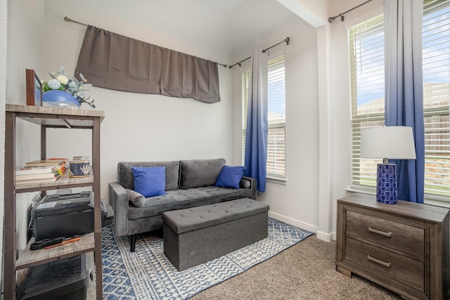 carpeted living area with baseboards