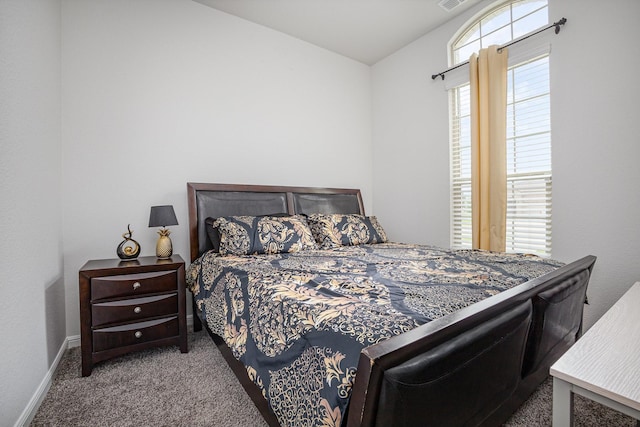 carpeted bedroom featuring vaulted ceiling and baseboards