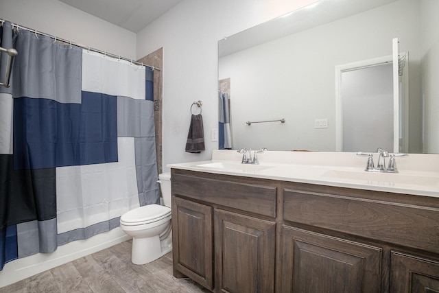 bathroom with toilet, wood finished floors, double vanity, and shower / tub combo with curtain