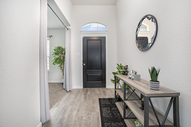entrance foyer with light wood-style flooring and baseboards