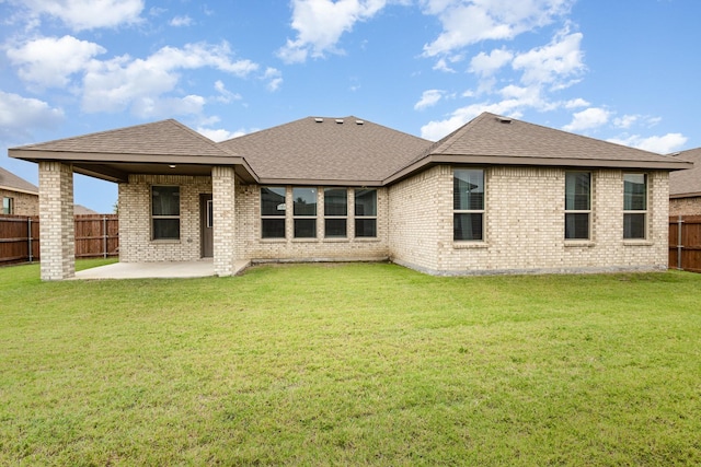 rear view of property featuring a patio, brick siding, and a shingled roof