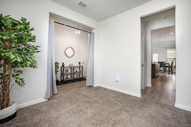 corridor featuring carpet floors, baseboards, and wood finished floors