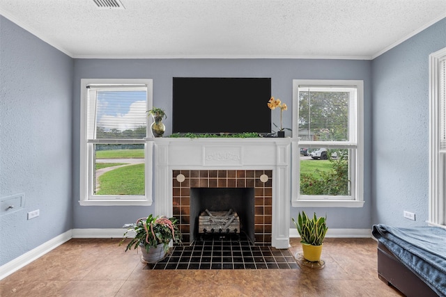 3801 Fort Ave, Waco, TX 76710 - living room with a textured ceiling, a textured wall, a tiled fireplace, crown molding, and baseboards