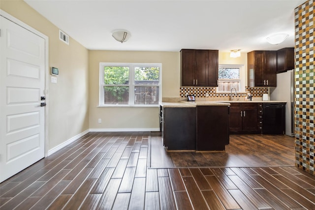 5818 Meadowick Ln, Dallas, TX 75227 - kitchen featuring black dishwasher, light countertops, dark wood-style floors, dark brown cabinetry, and decorative backsplash