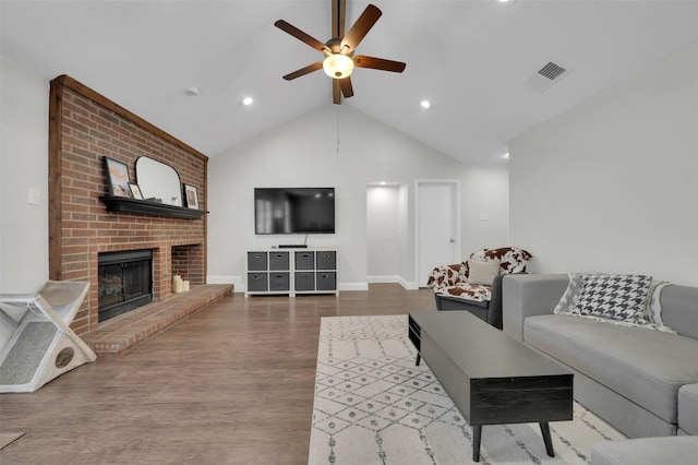 2434 Antler Trl, Lewisville, TX 75067 - living room with ceiling fan, a brick fireplace, vaulted ceiling, wood finished floors, and baseboards