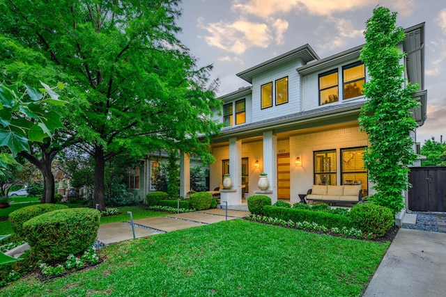 view of front facade with a porch, a yard, and an outdoor hangout area