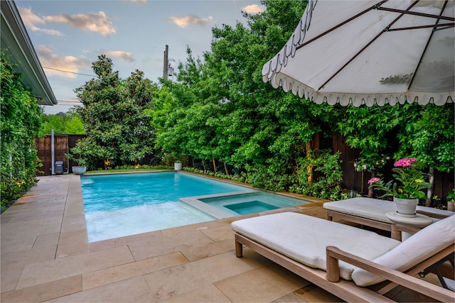 view of pool with a fenced backyard, a patio, and an in-ground hot tub