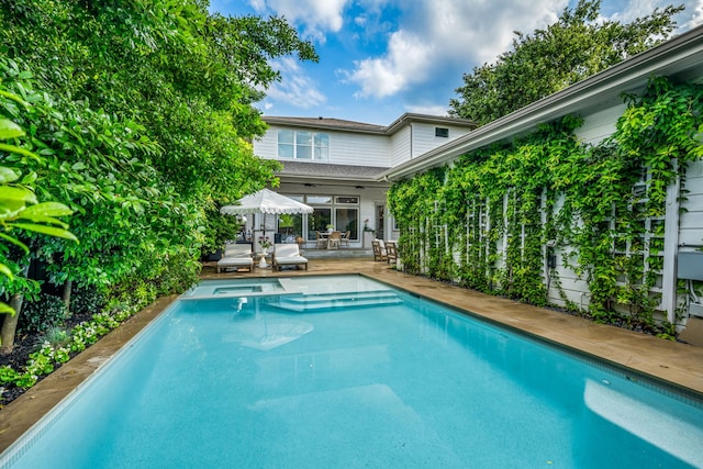 view of pool with a patio area and a pool with connected hot tub