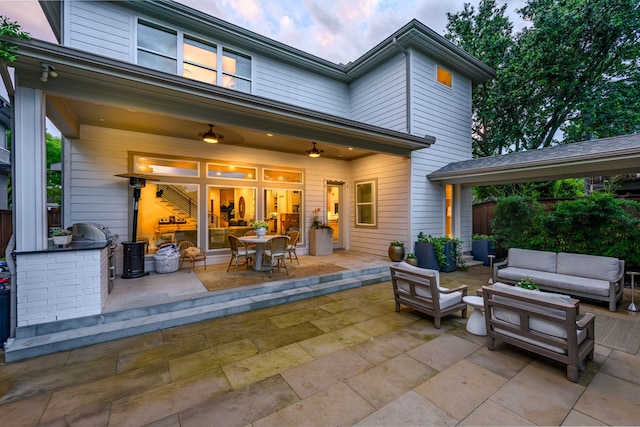 rear view of house featuring an outdoor living space, a patio area, outdoor dining area, and exterior kitchen
