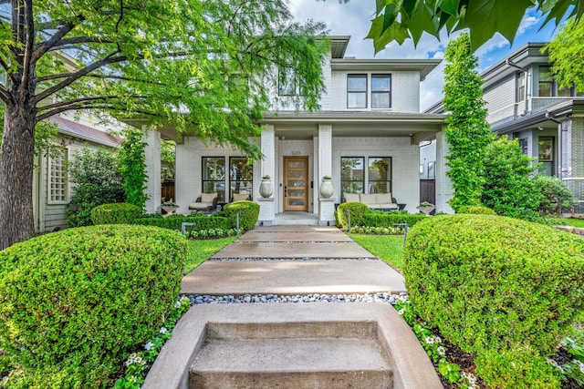 view of front of property featuring brick siding and covered porch