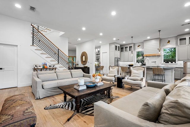 living area with stairway, recessed lighting, and light wood finished floors