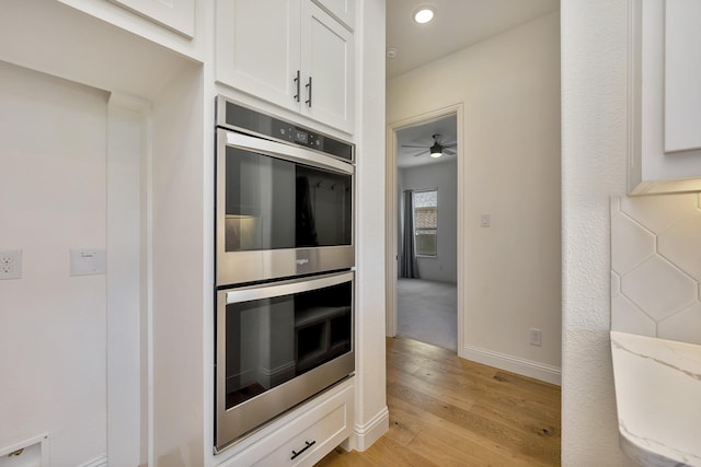 1208 Thornhill Ct, Roanoke, TX 76262 - kitchen featuring double oven, light wood-style floors, white cabinetry, ceiling fan, and baseboards