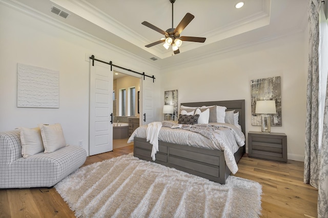 1208 Thornhill Ct, Roanoke, TX 76262 - bedroom featuring a barn door, a raised ceiling, crown molding, wood finished floors, and recessed lighting