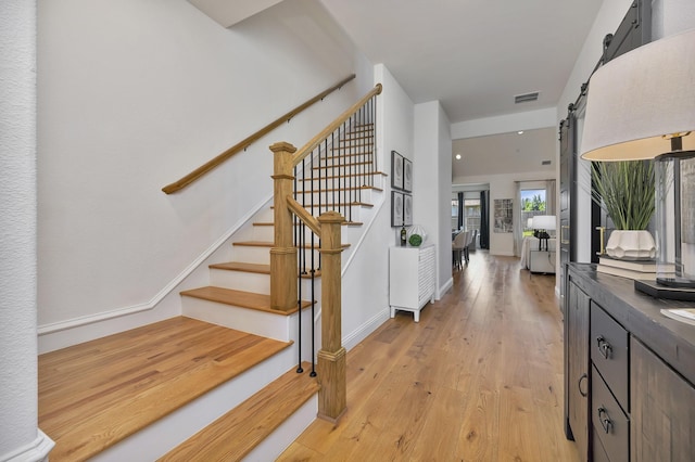1208 Thornhill Ct, Roanoke, TX 76262 - entrance foyer with a barn door, stairway, and light wood finished floors