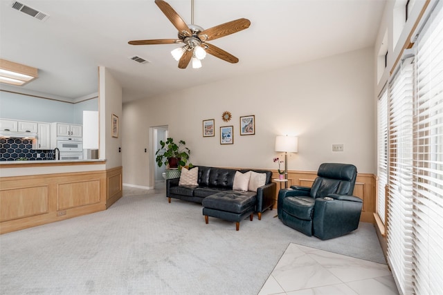 2203 Glen Helen Cir, Carrollton, TX 75007 - living room with a ceiling fan, a wainscoted wall, and light colored carpet