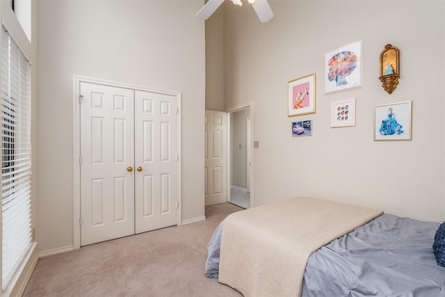 2203 Glen Helen Cir, Carrollton, TX 75007 - bedroom with light colored carpet, a towering ceiling, a closet, a ceiling fan, and baseboards