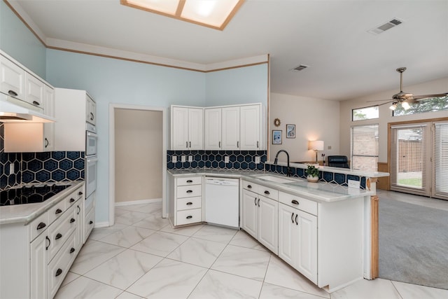 2203 Glen Helen Cir, Carrollton, TX 75007 - kitchen featuring white dishwasher, a sink, a peninsula, backsplash, and ceiling fan