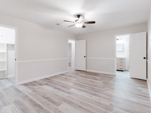 501 Edgewood Ave, Corsicana, TX 75110 - unfurnished bedroom featuring light wood finished floors, a spacious closet, baseboards, and ceiling fan