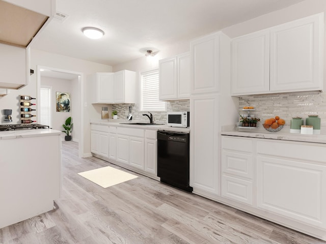 501 Edgewood Ave, Corsicana, TX 75110 - kitchen with dishwasher, white microwave, a sink, light countertops, and tasteful backsplash