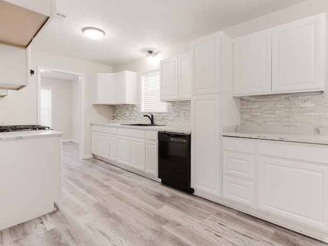 501 Edgewood Ave, Corsicana, TX 75110 - kitchen with dishwasher, a sink, decorative backsplash, light countertops, and white cabinetry