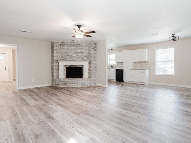 501 Edgewood Ave, Corsicana, TX 75110 - unfurnished living room featuring a ceiling fan, plenty of natural light, light wood-type flooring, and baseboards