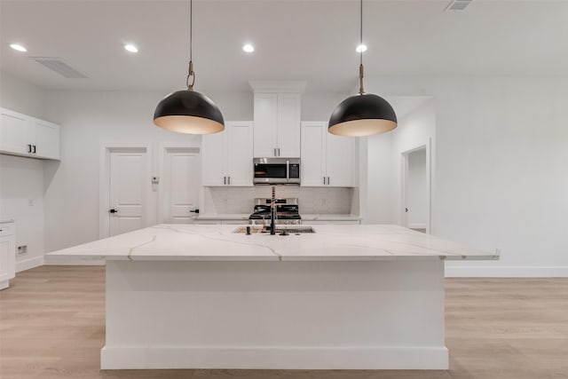 1008 Saint Matthew Cir, Royse City, TX 75189 - kitchen featuring stainless steel microwave, tasteful backsplash, a sink, light wood-style floors, and light stone counters