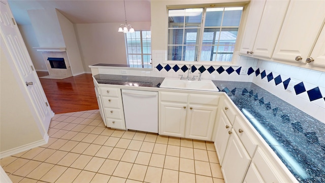 1913 Monte Cristo Way, Sherman, TX 75092 - kitchen featuring white dishwasher, a sink, a chandelier, dark countertops, and a fireplace with flush hearth