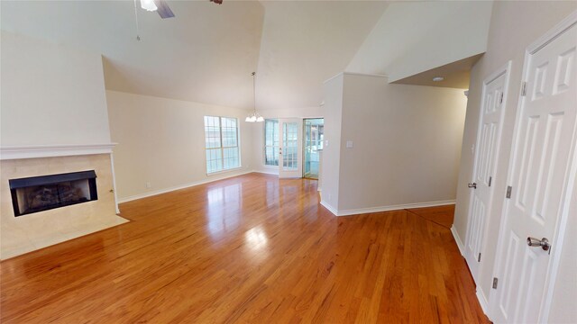 1913 Monte Cristo Way, Sherman, TX 75092 - unfurnished living room featuring light wood-type flooring, baseboards, a fireplace, ceiling fan, and high vaulted ceiling