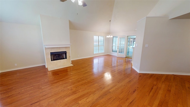 1913 Monte Cristo Way, Sherman, TX 75092 - unfurnished living room featuring a ceiling fan, a fireplace, light wood-type flooring, baseboards, and a chandelier