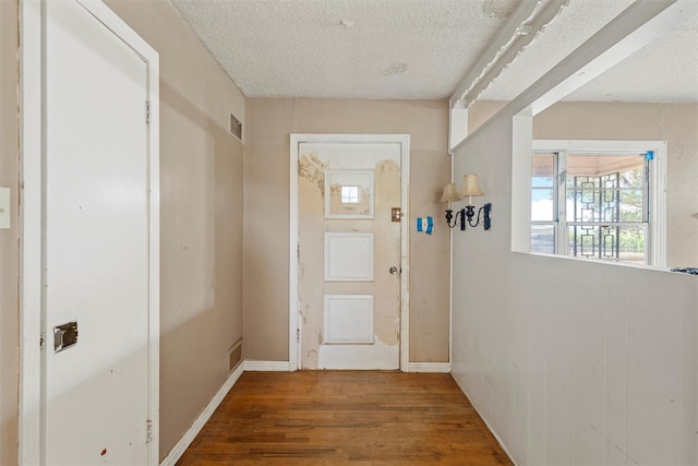 1677 Hobbs Ln, Waco, TX 76706 - doorway to outside with wood finished floors, a textured ceiling, and baseboards