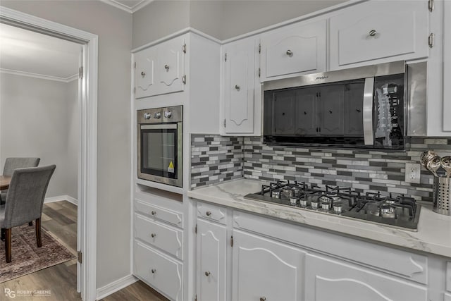 817 S Spruce St, Vivian, LA 71082 - kitchen featuring appliances with stainless steel finishes, crown molding, backsplash, white cabinets, and dark wood-style flooring