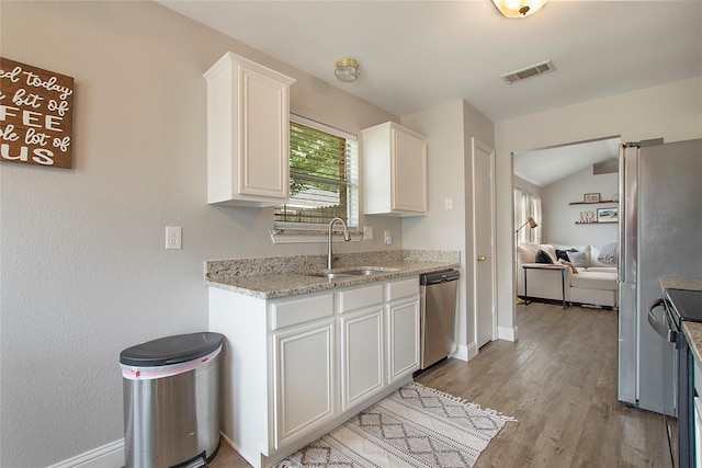 1034 Palomino Dr, Little Elm, TX 75068 - kitchen featuring stainless steel dishwasher, a sink, white cabinets, light wood-type flooring, and baseboards