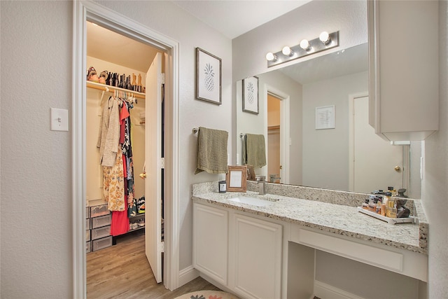 1034 Palomino Dr, Little Elm, TX 75068 - bathroom with wood finished floors, a walk in closet, and vanity