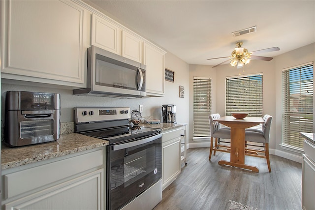 1034 Palomino Dr, Little Elm, TX 75068 - kitchen featuring stainless steel appliances, a ceiling fan, light wood-type flooring, and baseboards