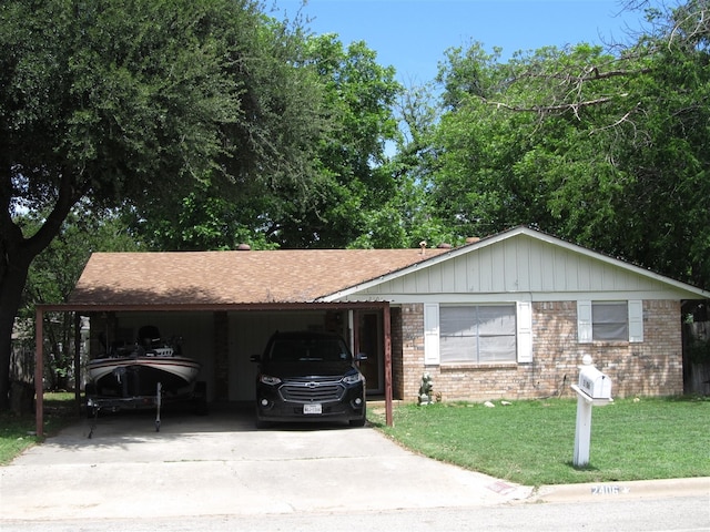 2406 14th Th, Brownwood, TX 76801 - ranch-style house featuring concrete driveway, brick siding, a front yard, a shingled roof, and an attached carport