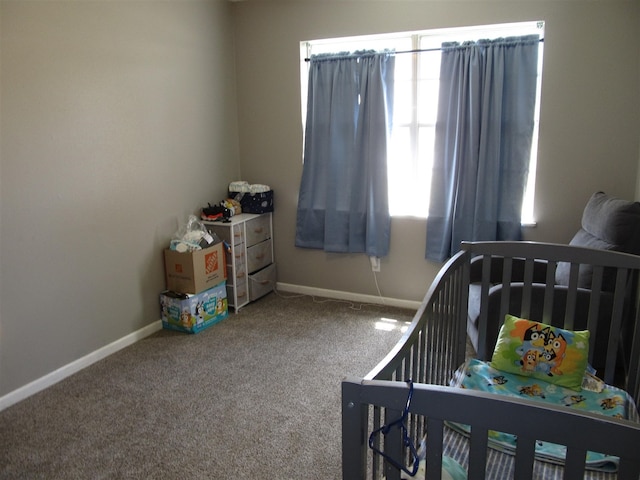 2406 14th Th, Brownwood, TX 76801 - carpeted bedroom featuring a crib, baseboards, and multiple windows