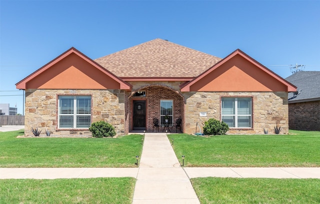 7201 Mcleod Dr, Abilene, TX 79602 - view of front facade featuring stone siding, roof with shingles, and a front lawn