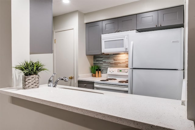 5130 Amesbury Dr Unit 103, Dallas, TX 75206 - kitchen with white appliances, a sink, tasteful backsplash, gray cabinets, and light stone counters