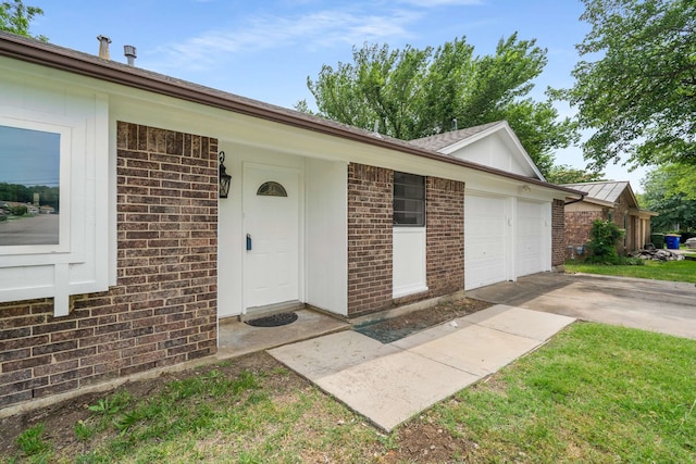 6012 Whispering Ln, Watauga, TX 76148 - view of exterior entry featuring brick siding, a garage, and driveway