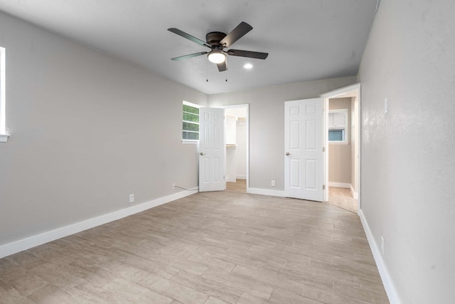6012 Whispering Ln, Watauga, TX 76148 - unfurnished bedroom with baseboards, light wood-style flooring, a walk in closet, a ceiling fan, and a closet