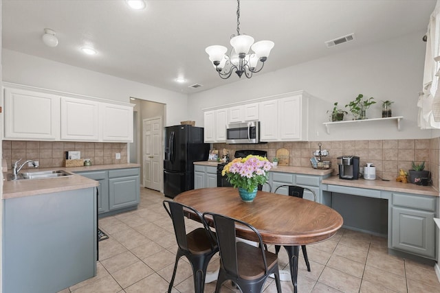 5305 Elmdale Dr, Watauga, TX 76137 - kitchen featuring stainless steel microwave, stove, a sink, tasteful backsplash, and a chandelier