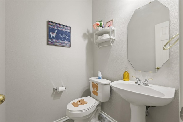 5305 Elmdale Dr, Watauga, TX 76137 - half bathroom featuring toilet, baseboards, and a sink