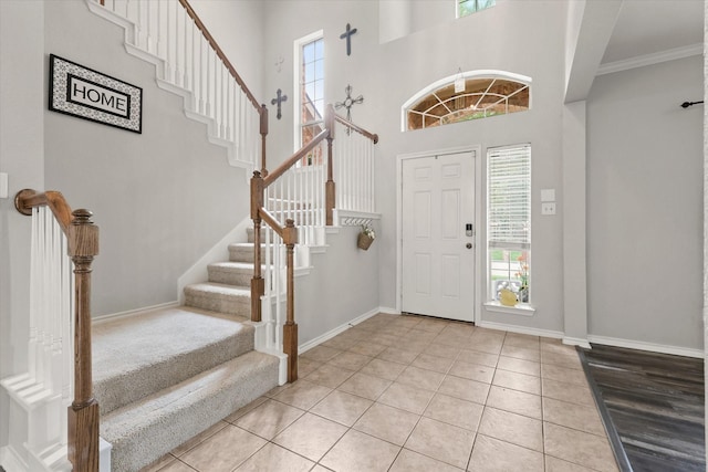 5305 Elmdale Dr, Watauga, TX 76137 - foyer featuring light tile patterned flooring, stairs, baseboards, crown molding, and a towering ceiling