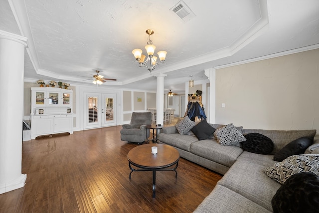 5005 Nevada Trl, North Richland Hills, TX 76180 - living room featuring a tray ceiling, a ceiling fan, ornate columns, a chandelier, and dark wood finished floors
