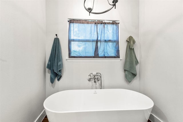 138 Sunset Dr, Gun Barrel City, TX 75156 - bathroom featuring a soaking tub, baseboards, and a chandelier